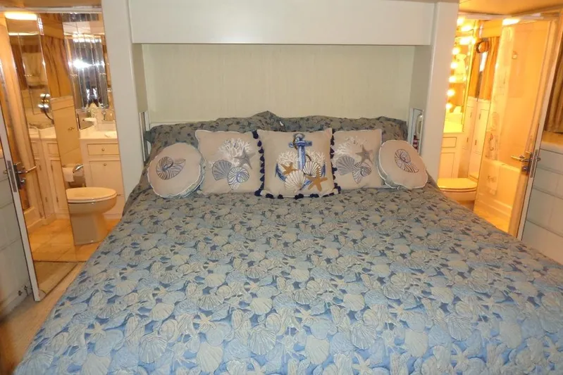  Yacht Photos Pics Luxurious bedroom on 1988 Burger 80 Motor Yacht with nautical-themed bedding and ensuite bathroom.