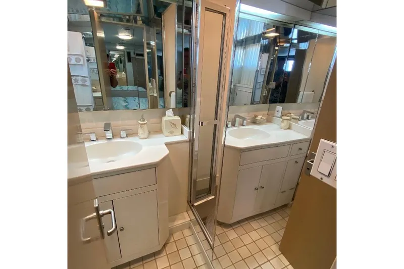  Yacht Photos Pics Bathroom interior of 1988 Burger 80 Motor Yacht with mirrored cabinets and modern fixtures.