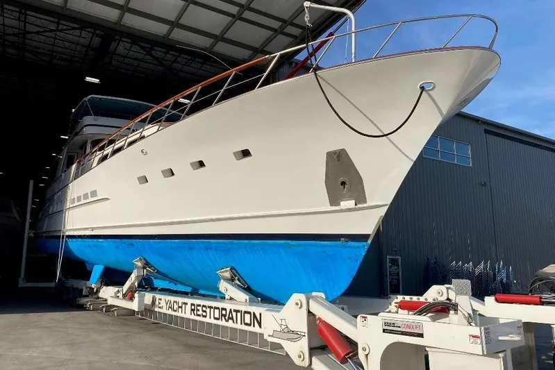  Yacht Photos Pics 1988 Burger 80 Motor Yacht in restoration facility, showcasing sleek design and blue hull.