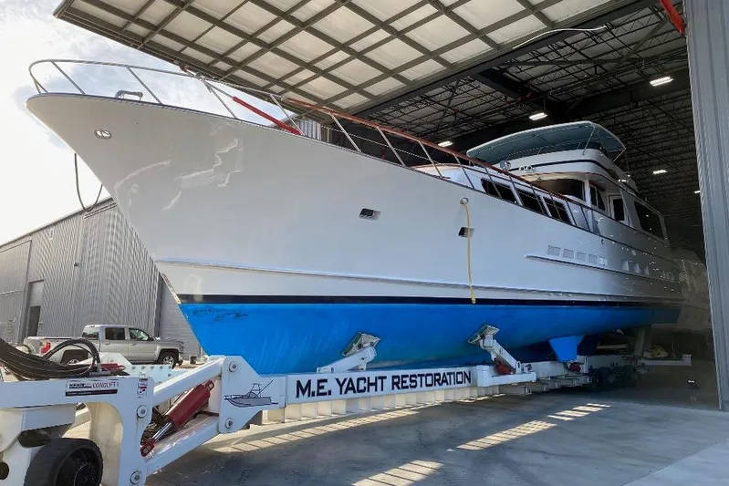  Yacht Photos Pics 1988 Burger 80 Motor Yacht in restoration facility, showcasing sleek design and blue hull.