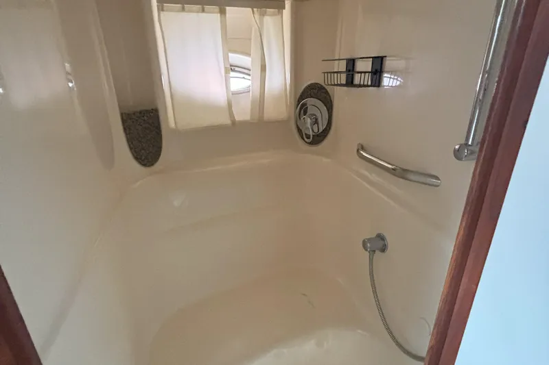 Yacht Photos Pics Shower area inside 2005 Sea Ray 420 Sundancer yacht, featuring curtain and chrome fixtures.