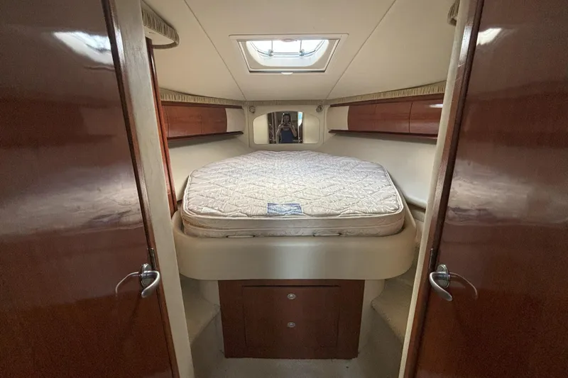  Yacht Photos Pics 2005 Sea Ray 420 Sundancer cabin interior with bed and wooden cabinetry.