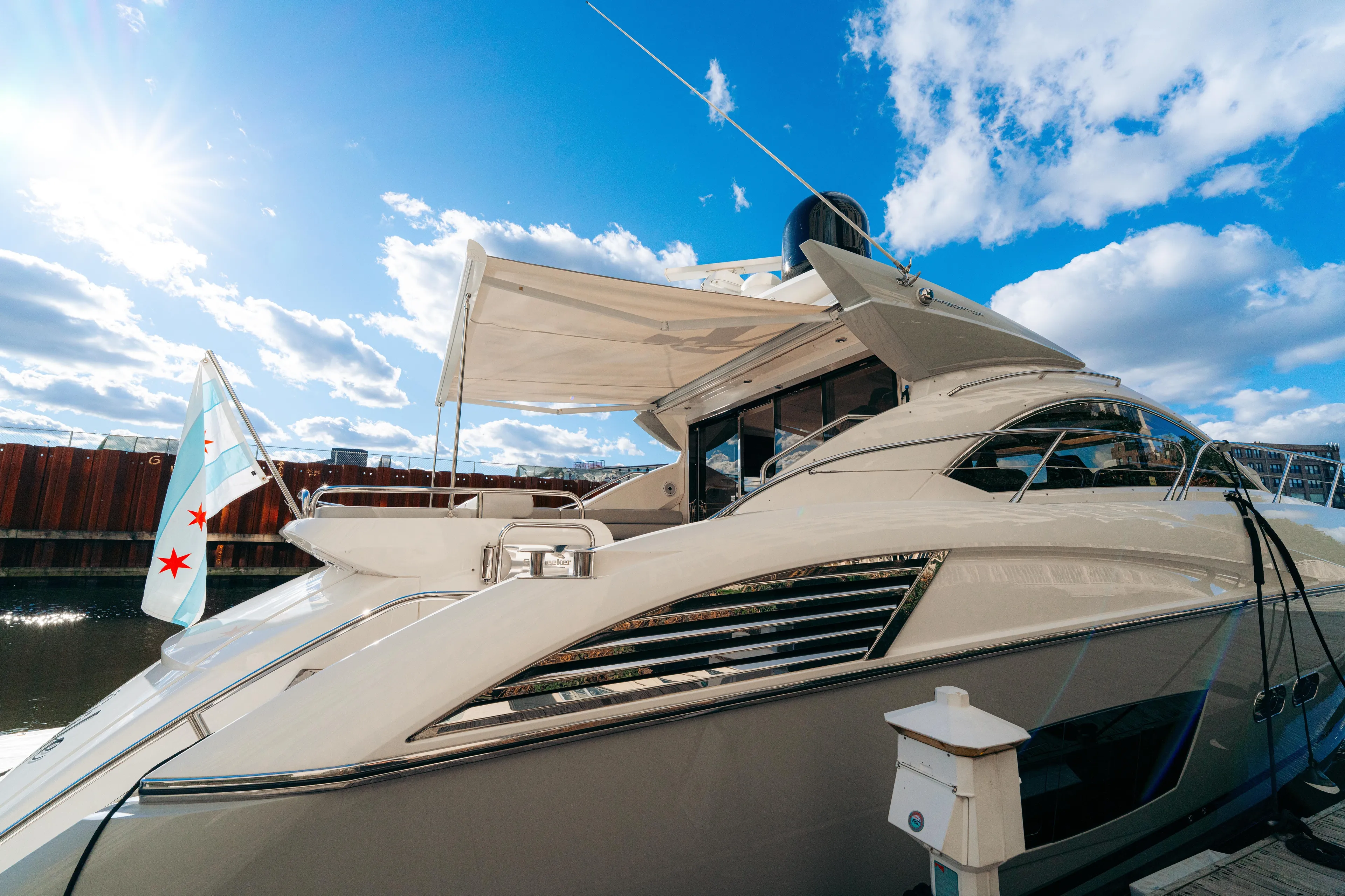  Yacht Photos Pics 2014 Sunseeker Predator 60 yacht docked under a bright blue sky.