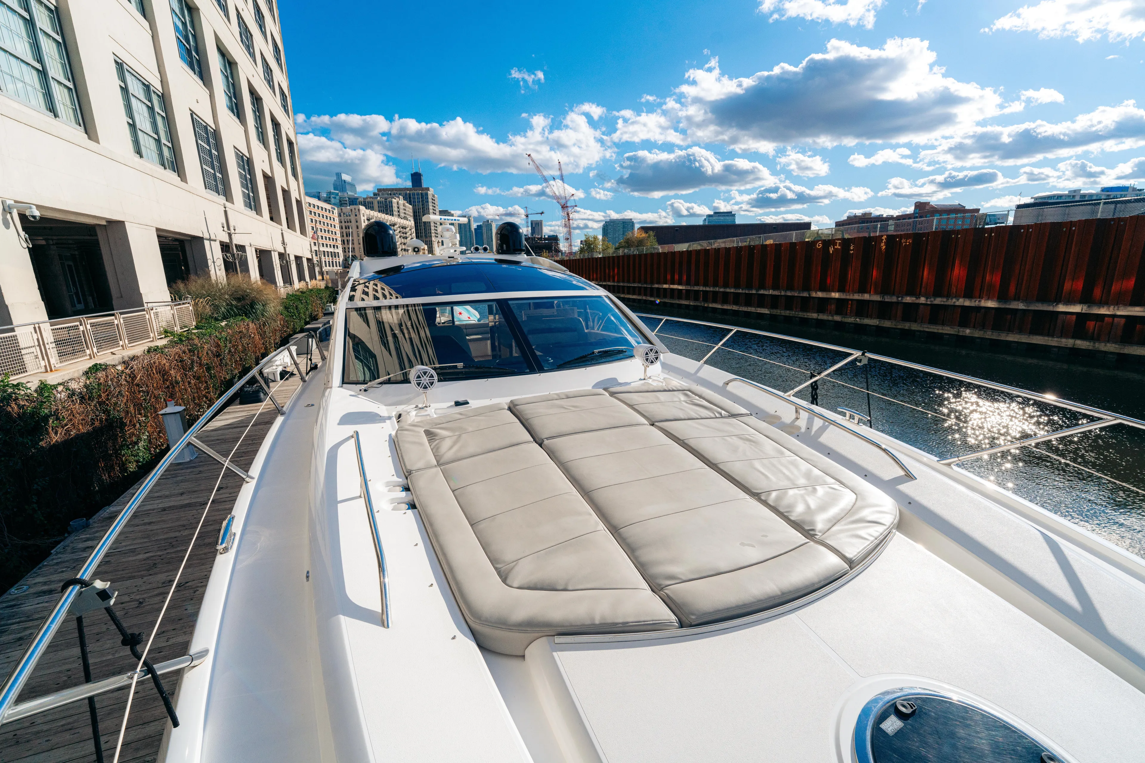  Yacht Photos Pics 2014 Sunseeker Predator 60 yacht docked by urban waterfront under blue sky.
