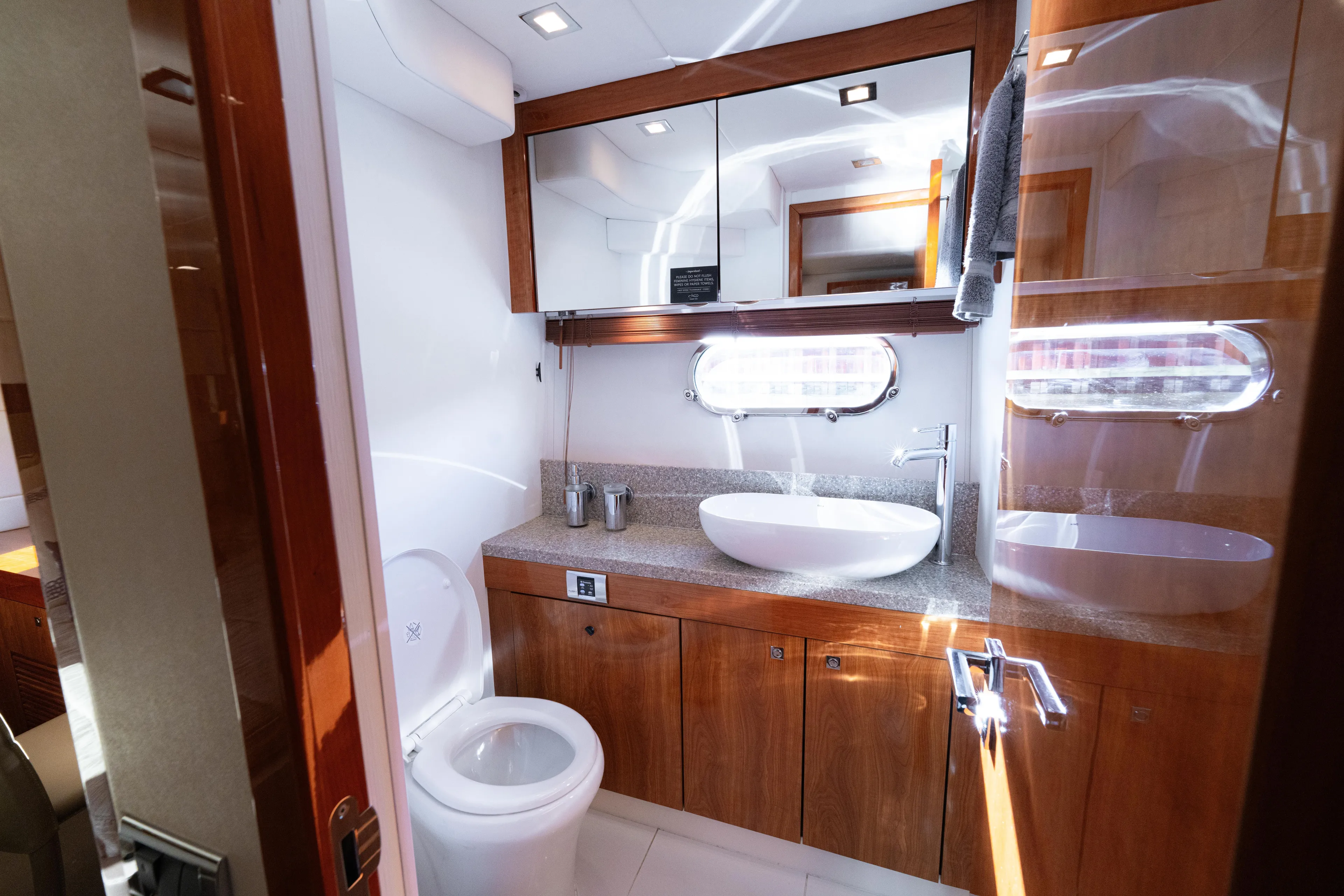  Yacht Photos Pics Luxurious bathroom in 2014 Sunseeker Predator 60 yacht with modern fixtures and wood accents.