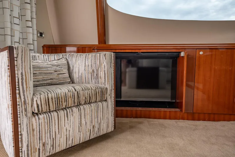 Water Ranch Yacht Photos Pics Luxurious interior of 2003 Lazzara 80 EB yacht with elegant striped armchair and wooden cabinetry.