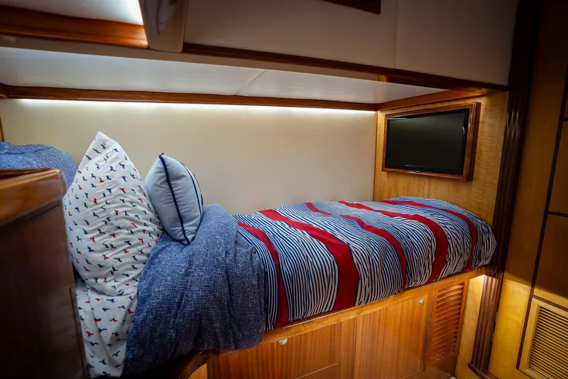 Trident Yacht Photos Pics Cozy cabin interior of 2015 Maverick Yachts Costa Rica 50 with striped bedding and pillows.
