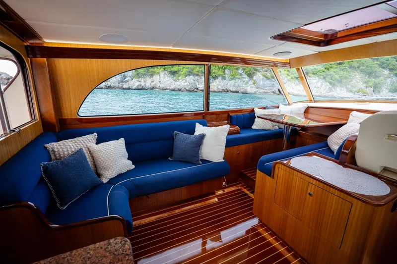 Trident Yacht Photos Pics Luxurious interior of 2015 Maverick Yachts Costa Rica 50, featuring elegant wood and blue seating.