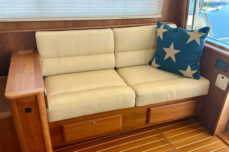 Encore Yacht Photos Pics Interior of 2017 Sabre 42 Salon Express with beige sofa and star-patterned pillow.