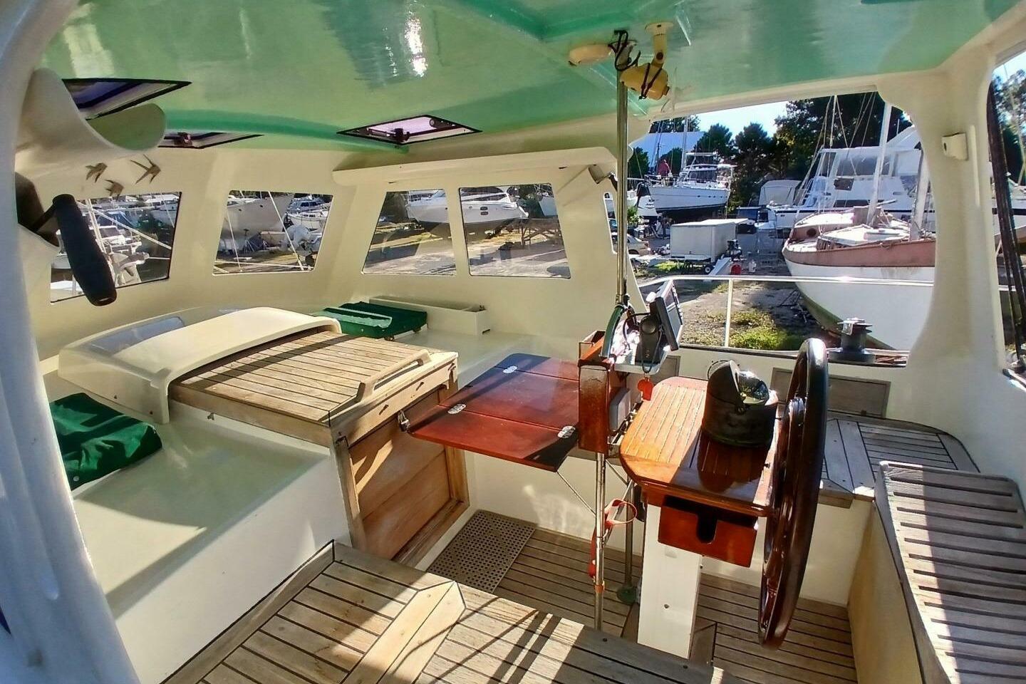 Interior of 1980 Hardin 45 sailboat with wooden helm and seating area.