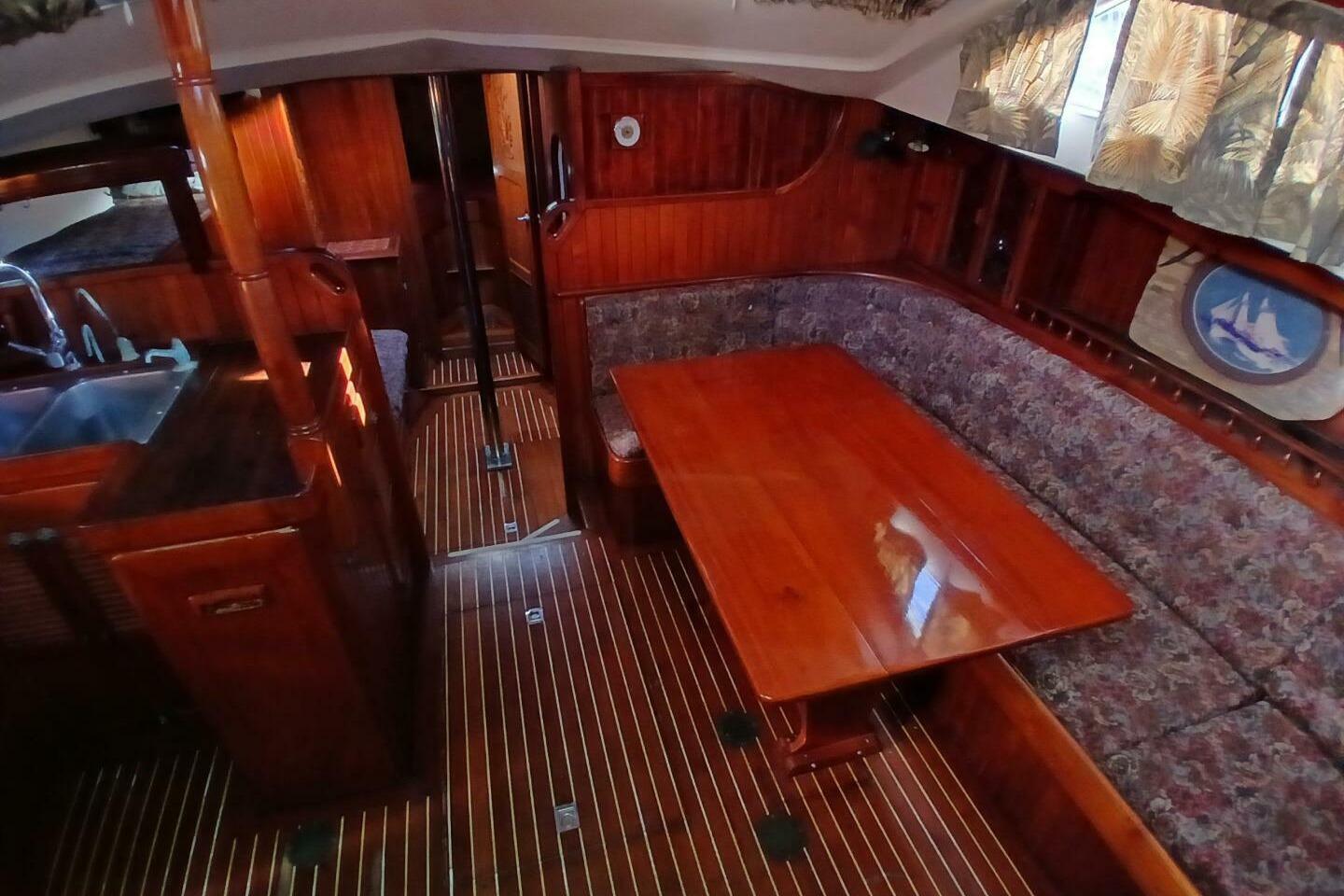 Interior of 1980 Hardin 45 sailboat with wooden furnishings and cozy seating area.