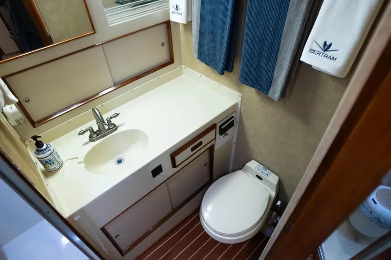Barefoot Girl Yacht Photos Pics 1984 Bertram 35 Convertible yacht bathroom with sink, toilet, and branded towels.