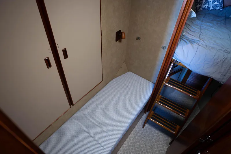 Barefoot Girl Yacht Photos Pics 1984 Bertram 35 Convertible cabin interior with bed, stairs, and storage.