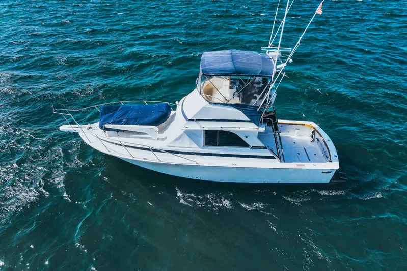 Barefoot Girl Yacht Photos Pics 1984 Bertram 35 Convertible yacht cruising on open water, aerial view.