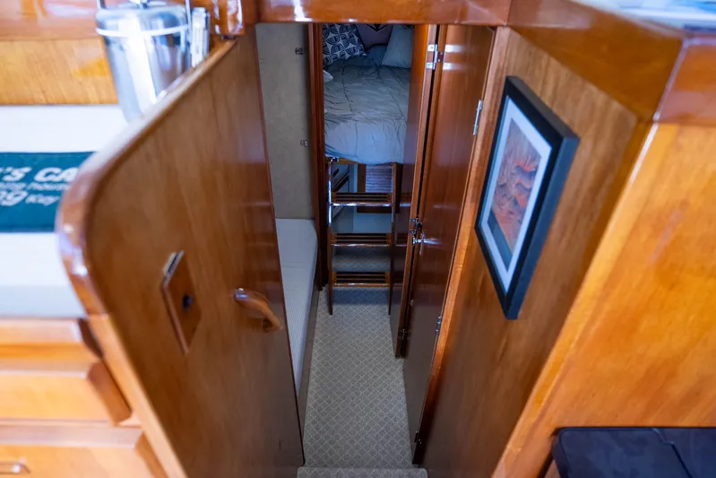 Barefoot Girl Yacht Photos Pics Interior of 1984 Bertram 35 Convertible yacht with wooden finishes and cozy sleeping area.