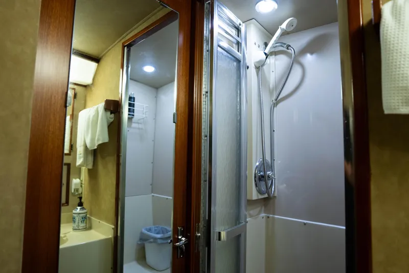 Barefoot Girl Yacht Photos Pics Bathroom interior of 1984 Bertram 35 Convertible yacht with shower and wooden accents.