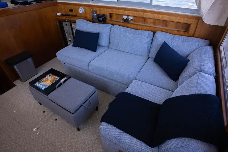 Barefoot Girl Yacht Photos Pics Interior of 1984 Bertram 35 Convertible with cozy gray sofa and navy cushions.