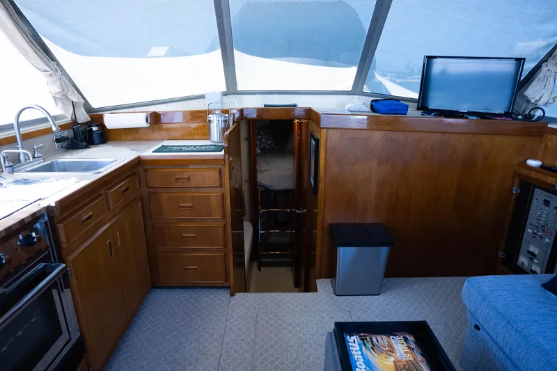 Barefoot Girl Yacht Photos Pics Interior of 1984 Bertram 35 Convertible yacht with kitchen and seating area.
