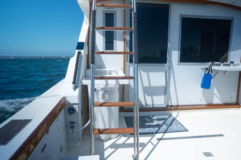 Barefoot Girl Yacht Photos Pics 1984 Bertram 35 Convertible yacht deck with ladder, ocean view, and clear blue sky.