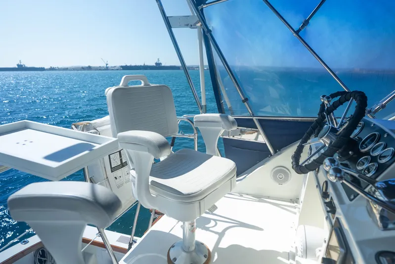 Barefoot Girl Yacht Photos Pics 1984 Bertram 35 Convertible yacht helm with ocean view, featuring captain's chair and steering wheel.