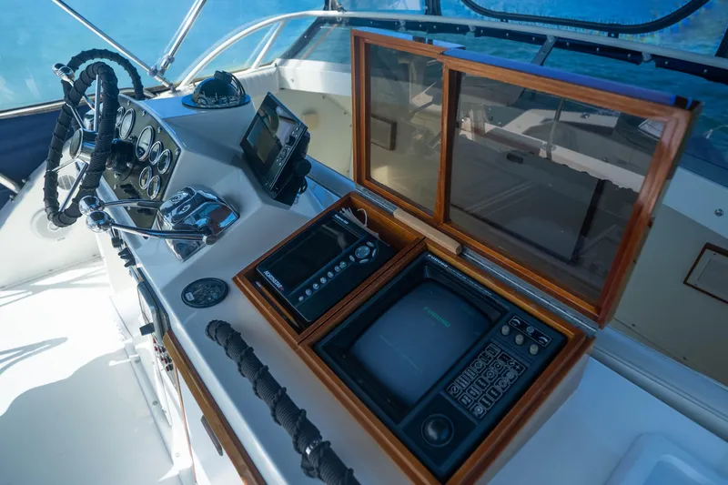 Barefoot Girl Yacht Photos Pics 1984 Bertram 35 Convertible helm with vintage navigation equipment and steering wheel.