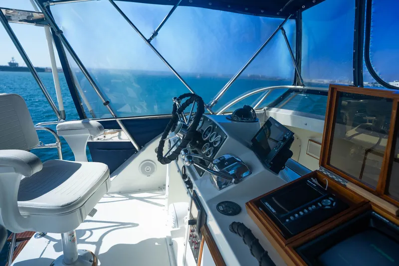Barefoot Girl Yacht Photos Pics Interior view of 1984 Bertram 35 Convertible yacht cockpit with steering wheel and controls.