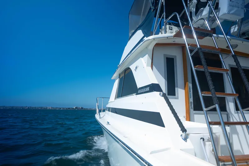 Barefoot Girl Yacht Photos Pics 1984 Bertram 35 Convertible yacht cruising on open water under clear blue sky.