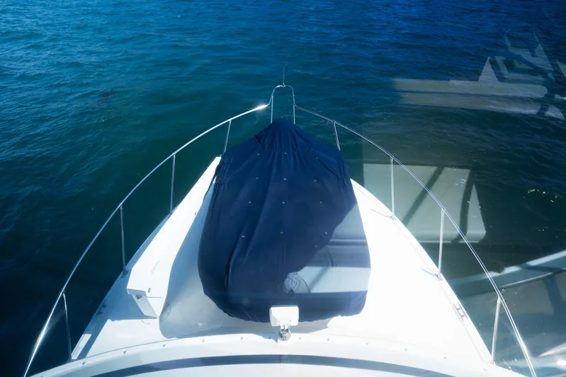 Barefoot Girl Yacht Photos Pics 1984 Bertram 35 Convertible boat bow view on calm blue water.
