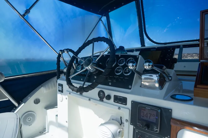 Barefoot Girl Yacht Photos Pics Cockpit of 1984 Bertram 35 Convertible boat with steering wheel and navigation instruments.