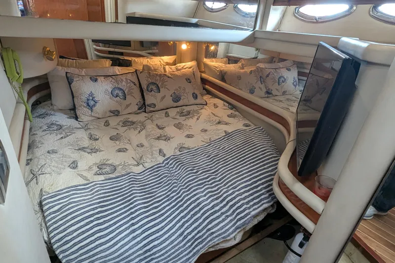  Yacht Photos Pics Cozy bedroom interior of 1998 Sea Ray 480 Sedan Bridge yacht with nautical-themed bedding.