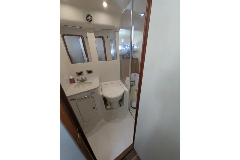  Yacht Photos Pics Bathroom interior of 1998 Sea Ray 480 Sedan Bridge yacht, featuring sink and toilet.