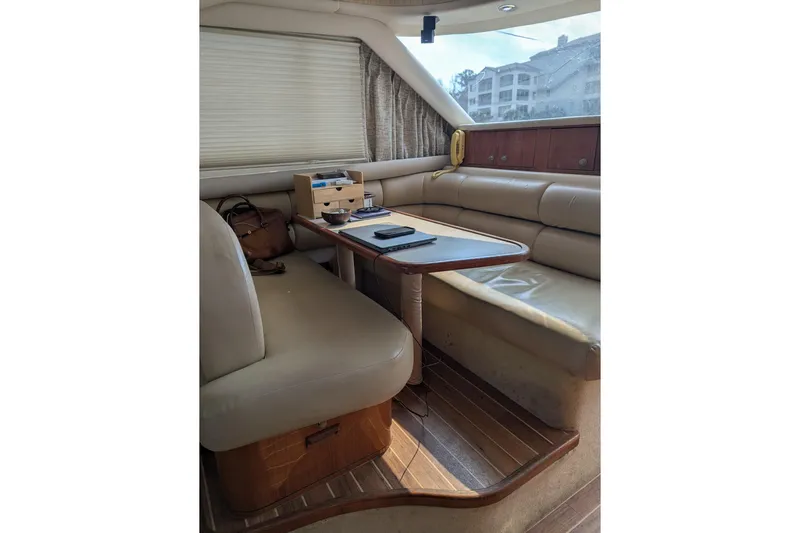  Yacht Photos Pics 1998 Sea Ray 480 Sedan Bridge interior with beige seating and wooden table.