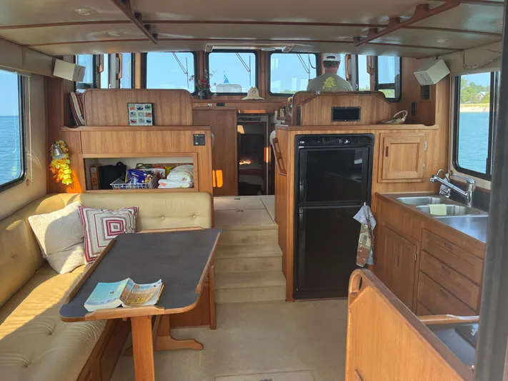Nomad Yacht Photos Pics Interior of a 2000 Nordic Tug 37, featuring a cozy seating area and kitchenette.