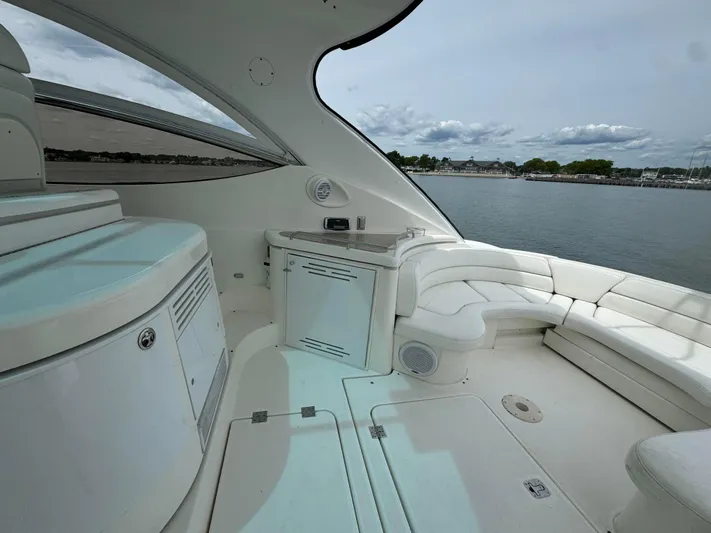  Yacht Photos Pics 2003 Cruisers Yachts 540 Express interior with white seating and cabinetry, overlooking calm waters.