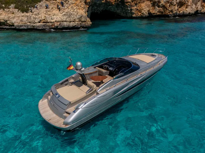Vimojal II Yacht Photos Pics Luxurious 2009 Riva 52' le yacht cruising in clear turquoise waters near rocky coastline.