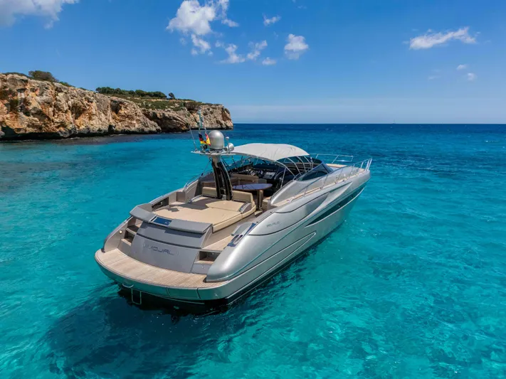 Vimojal II Yacht Photos Pics Luxurious 2009 Riva 52' LE yacht cruising in clear blue waters near rocky coastline.