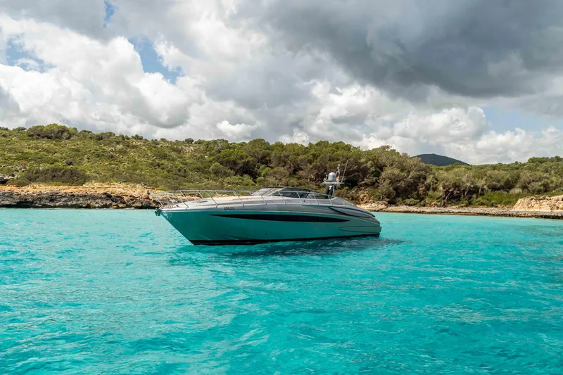 Vimojal II Yacht Photos Pics Luxurious 2009 Riva 52' le yacht on turquoise waters, scenic coastal backdrop.