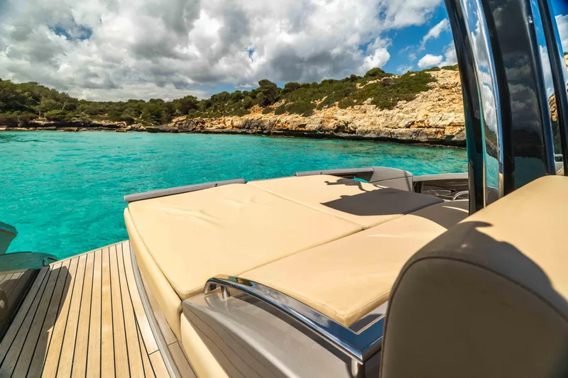 Vimojal II Yacht Photos Pics Luxurious 2009 Riva 52' le yacht on turquoise waters near rocky coastline.