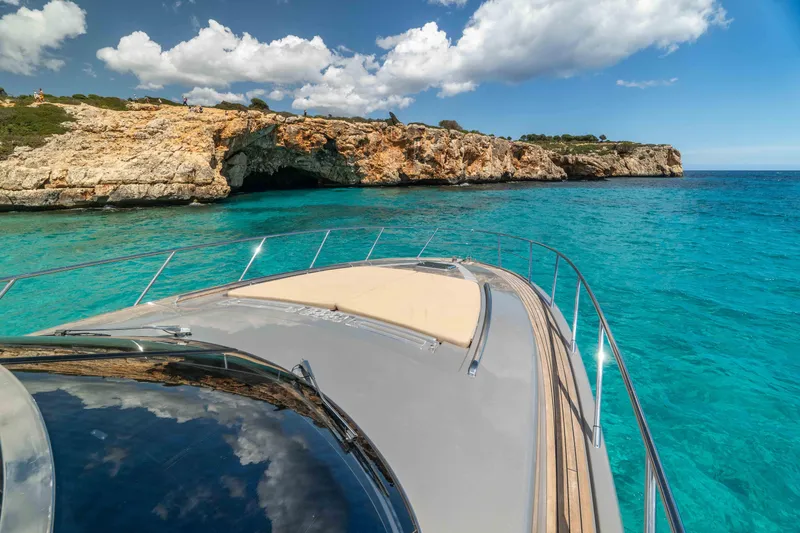 Vimojal II Yacht Photos Pics Luxury Riva 52' le yacht cruising near rocky coastline, clear turquoise water, 2009 model.