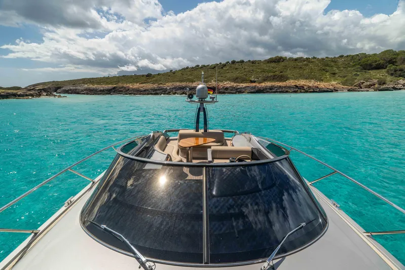 Vimojal II Yacht Photos Pics Luxurious 2009 Riva 52' le yacht cruising in turquoise waters under a partly cloudy sky.