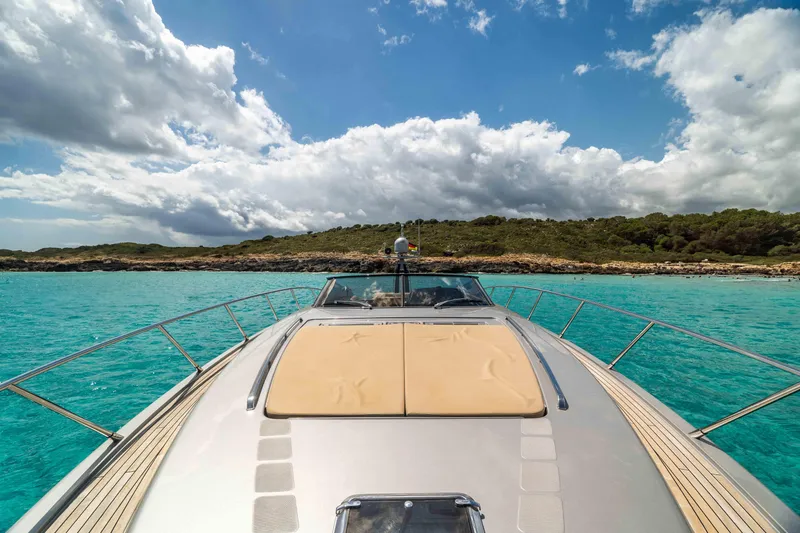 Vimojal II Yacht Photos Pics Luxurious 2009 Riva 52' le yacht cruising in turquoise waters under a partly cloudy sky.