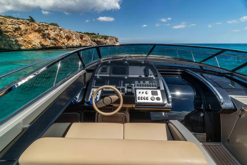Vimojal II Yacht Photos Pics Cockpit view of 2009 Riva 52' le yacht, overlooking turquoise waters and rocky coastline.