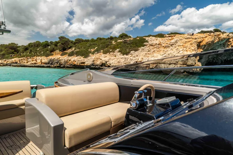 Vimojal II Yacht Photos Pics Luxurious 2009 Riva 52' le yacht cruising near rocky coastline and turquoise waters.