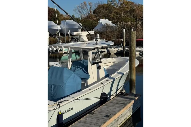  Yacht Photos Pics 2023 Regulator 31 boat docked, featuring Garmin equipment and blue covers.