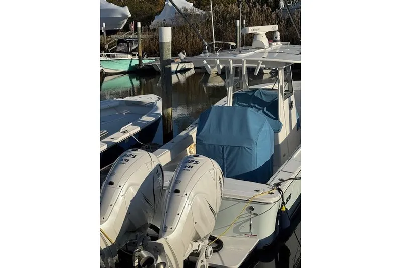  Yacht Photos Pics 2023 Regulator 31 boat docked with twin outboard engines and blue cover.