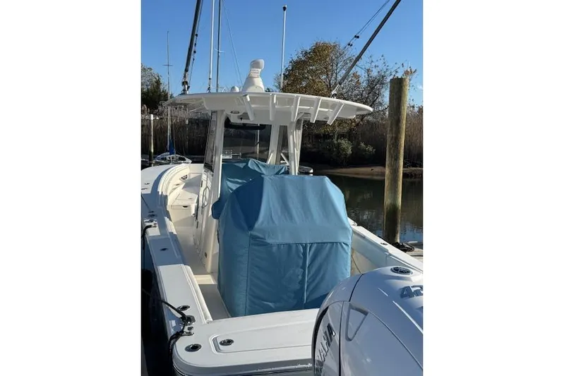  Yacht Photos Pics 2023 Regulator 31 boat with blue covers, docked in a marina.