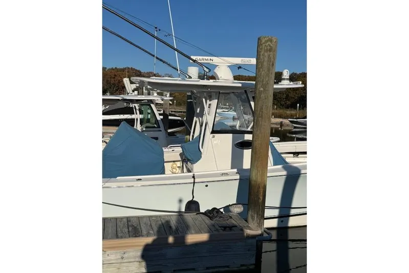  Yacht Photos Pics 2023 Regulator 31 boat docked, featuring Garmin equipment and covered seating.