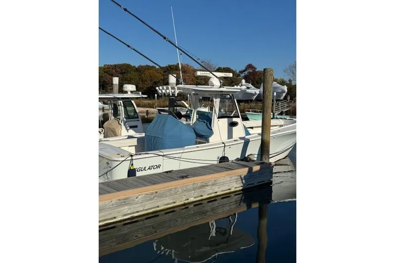  Yacht Photos Pics 2023 Regulator 31 boat docked at marina under clear blue sky.