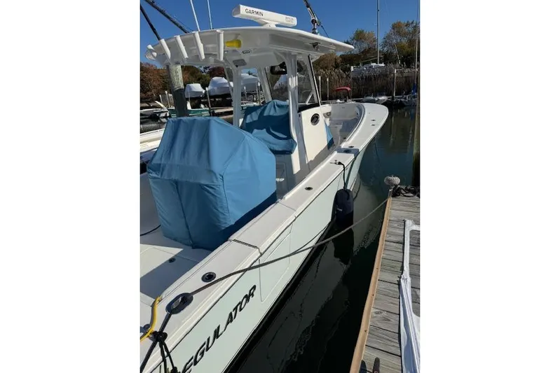  Yacht Photos Pics 2023 Regulator 31 boat docked, featuring covered seating and Garmin equipment.