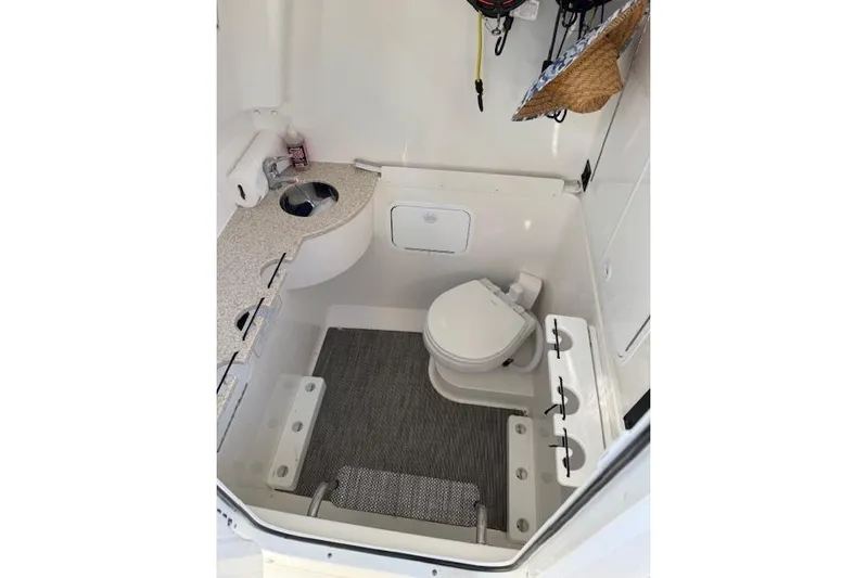  Yacht Photos Pics 2023 Regulator 31 boat bathroom with toilet, sink, and storage space.